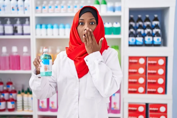 Jovem Árabe Mulher Trabalhando Farmácia Farmácia Segurando Xarope Cobrindo Boca — Fotografia de Stock