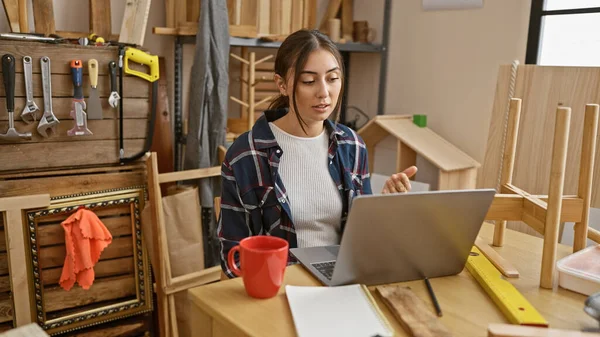 Spaanse Vrouw Met Laptop Een Timmerwerkplaats Omringd Door Gereedschap Houtwerk — Stockfoto
