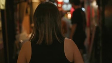 Güzel İspanyol kadın uzaklaşıyor, Tokyo sokaklarında geziniyor, gece ışıklarına geri dönüp bakıyor.