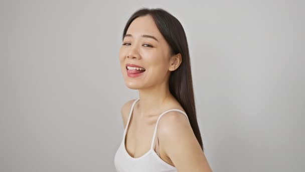 一个身穿白色背心的笑着的亚洲女人自信地在白底衬托下摆姿势 — 图库视频影像