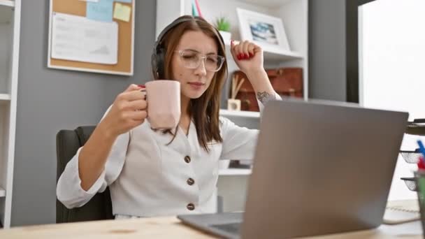 Młoda Kobieta Korzysta Przerwy Kawę Biurze Słuchawkami Laptopem — Wideo stockowe