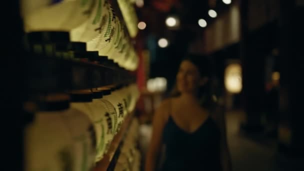 美しい若いヒスパニック女性が夜東京の日本の寺院でアジアのランタンを眺める — ストック動画