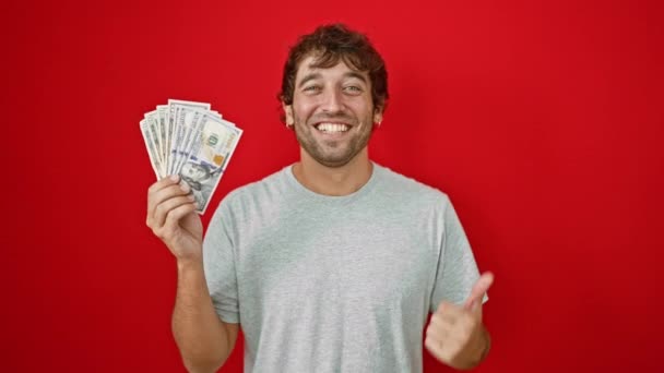Веселый Молодой Человек Радостно Выставляет Напоказ Американские Банкноты Указывая Сторону — стоковое видео