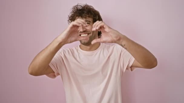 Веселый Молодой Человек Делает Сердце Формы Руками Розовом Изолированном Фоне — стоковое видео