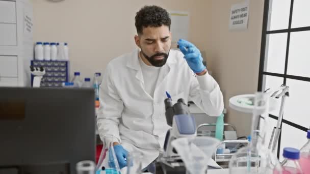 실험실 코트를 집중적인 남자는 실험실에서 액체로 실험을 수행하여 전문성과 집중력을 — 비디오