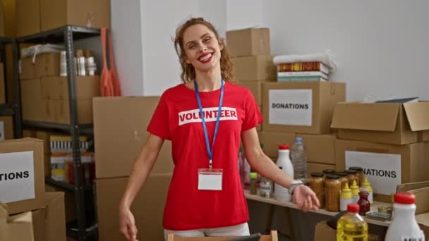 寄付箱でいっぱいのストーリーテロームで彼女のシャツを指す陽気な白人女性ボランティア — ストック動画