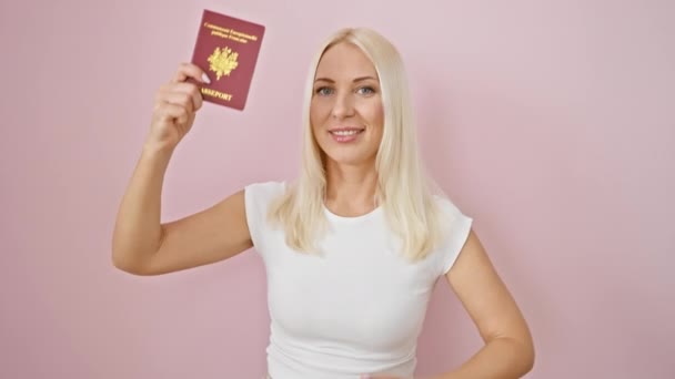 一个快乐 迷人的金发年轻女人闪烁着自信的微笑和 的手势 表示她的认可 用法国护照盖住了孤立的粉色背景 — 图库视频影像