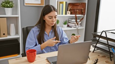 Genç İspanyol bir kadının modern ofis ortamında profesyonellik ve nişanlanma ile ilgili bir video konuşması var..