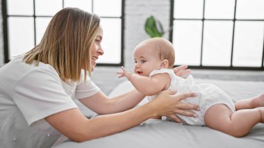 Anne ve kız, eğlenceli, sıradan bir oyun oynuyorlar yatak odasında oturuyorlar, havalı ve kendinden emin görünüyorlar, neşe, mutluluk ve güzel, pozitif bir yaşam tarzları var..
