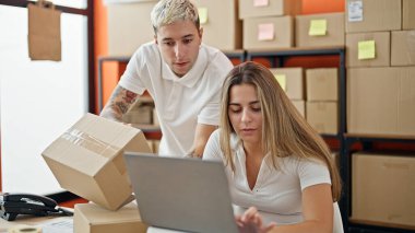 Ofiste dizüstü bilgisayarı kullanan iki işçi ve kadın.