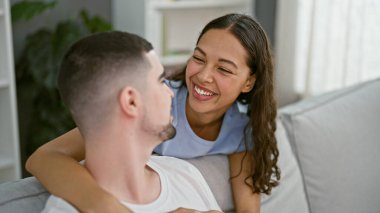 Güzel çiftlerin neşeli anları, tesadüfen kucaklaşmaları, gülümsemeleri ve evdeki kanepede birlikte hayatın tadını çıkarmaları.