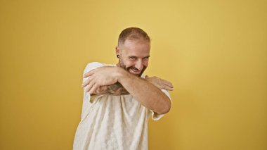 Genç adam kendine güveni tam sarı arka planda sarılıyor.