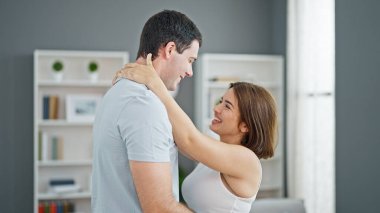 Güzel bir çift ayakta birbirlerine sarılıyor ve gülümsüyor.