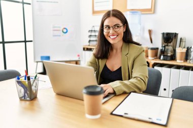 Young beautiful hispanic woman business worker using laptop working at office