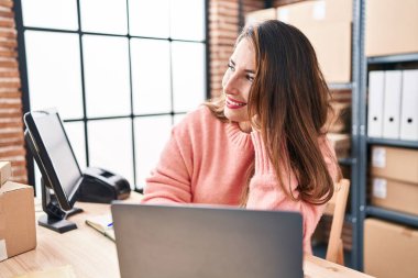 Young beautiful hispanic woman ecommerce business worker using laptop working at office