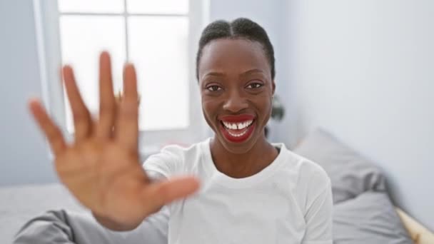 Веселая Африканская Американка Лежащая Кровати Сияющая Указывающая Пятью Пальцами Спальне — стоковое видео