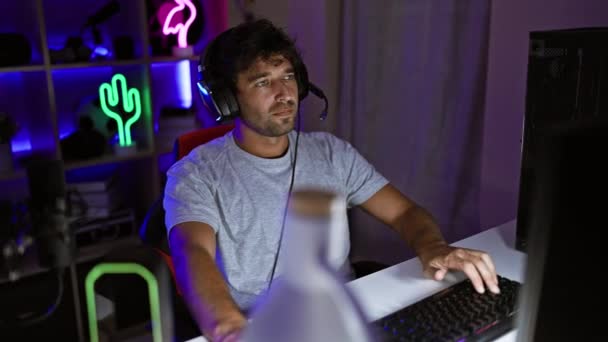 Skupiony Mężczyzna Słuchawkami Korzysta Nocy Komputera Neonowym Pokoju Gier Przedstawiając — Wideo stockowe