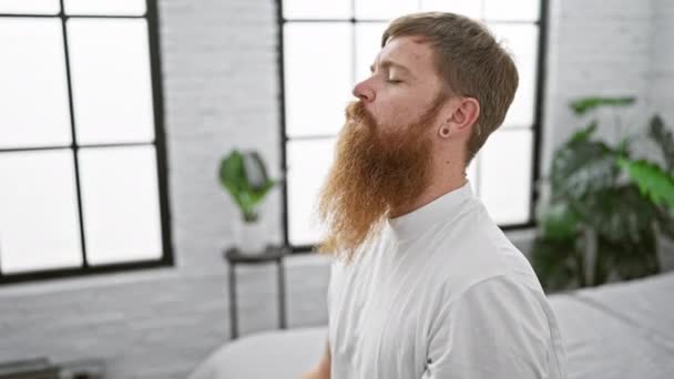 一个英俊的红头发男人发现他的早晨正在锻炼 他正坐在床上平静地躺在床上 专心练瑜伽 — 图库视频影像