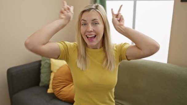 그녀의 사랑스러운 거실에서 편안한 티셔츠를 집에서 분위기에서 제스처로 재미를 사랑스럽게 — 비디오
