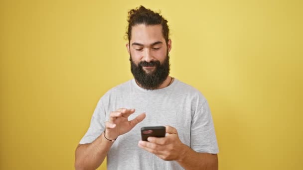 Usmívající Mladý Hispánec Vousy Drží Smartphone Žlutém Pozadí — Stock video