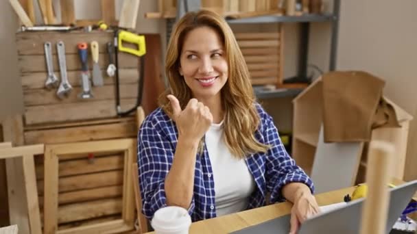 Jovem Confiante Bela Mulher Latina Carpintaria Sentado Mesa Sorrindo Apontando — Vídeo de Stock
