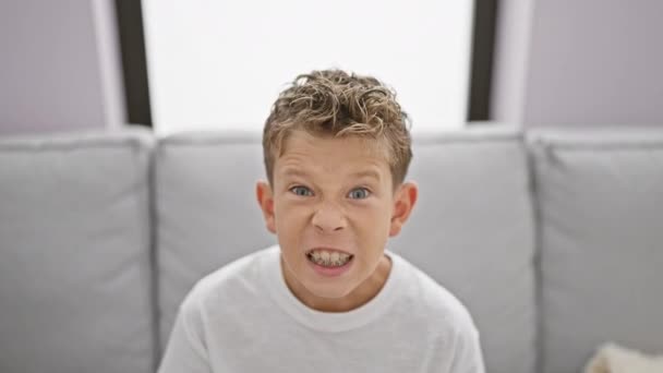 Roztomilý Blonďatý Chlapec Sedící Doma Pohovce Vyjadřující Hlasitou Frustraci Vztek — Stock video