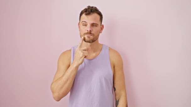 穿着无袖T恤的快乐的年轻人表现出了一个聪明的想法 在一个孤立的粉色背景上摆出顽皮的指尖的手势 — 图库视频影像