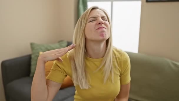 티셔츠에 금발의 여자는 집에서 폭력을 제스처에 손으로 그녀의 공기를 — 비디오