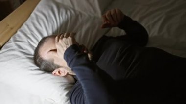 Yatağında sakallı İspanyol kel bir adam, gecenin karanlığında stres, huzursuzluk ya da hastalık belirtileri gösteriyor..