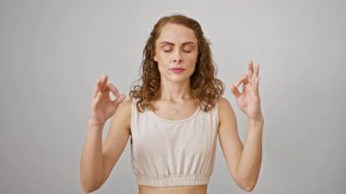 Yoga ve meditasyon yoluyla iç huzuru bulan çekici genç bir kadın, sağlıklı bir pozda gözleri kapalı duruyor, sakin, izole edilmiş arka planda huzur yayıyor.