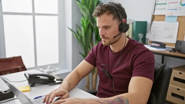 Mladý Vousatý Muž Pracuje Pozorně Kanceláři Sluchátka Před Notebookem Vyzařuje — Stock video