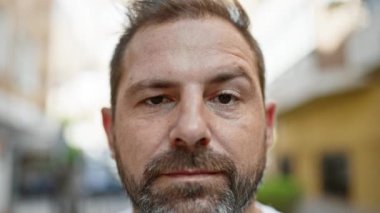 Şehir caddesinde gri saçlı, olgun sakallı bir adamın portresi..