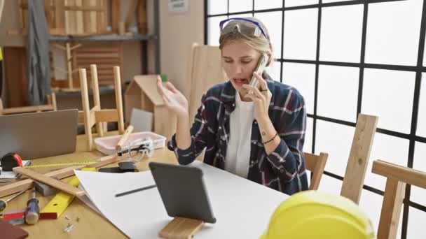 Mulher Loira Oficina Falando Telefone Enquanto Navega Tablet Meio Ferramentas — Vídeo de Stock