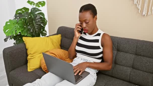 African American Woman Using Laptop Talking Smartphone Home — Stok video