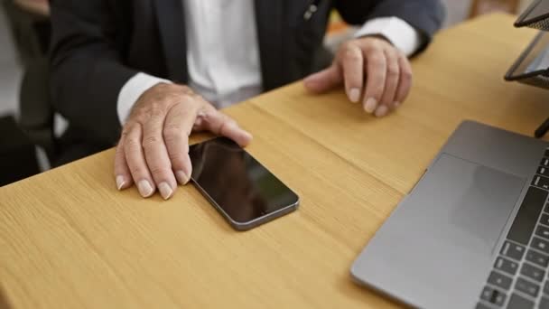 一位优雅的老人 一位行政人员 专心致志于办公室的商务工作 坐在办公桌前 在笔记本电脑上打字 用手机 这就是成功的职业人士的定义 — 图库视频影像