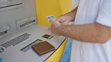 Avustralya doları tutan yakışıklı, orta yaşlı beyaz bir adam. Şehir ATM 'sinde bir iş sırasında yakalanmış. Açık hava bankacılık teknolojisi iş başında, Avustralya 'dan para çeken kişi..