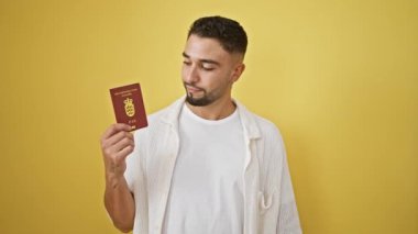Sarı arka planda Danimarka pasaportu taşıyan yakışıklı bir adam gülümsüyor.