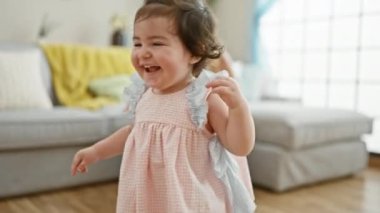 Neşeli anne kızını kucaklıyor, kıkırdıyor ve parıldıyor sıcak evde gülümsüyor.