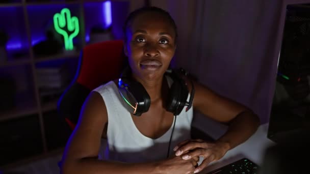 Afrikanerin Mit Kopfhörern Lächelt Einem Spielzimmer Mit Neonbeleuchtung Der Nacht — Stockvideo