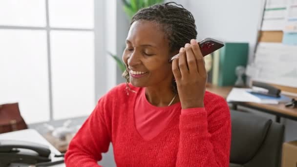 Μια Χαρούμενη Αφροαμερικάνα Κόκκινα Χρησιμοποιώντας Ένα Smartphone Ένα Φωτεινό Περιβάλλον — Αρχείο Βίντεο