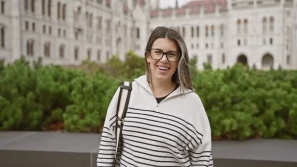 Una Joven Alegre Con Gafas Suéter Rayas Sonríe Mientras Explora — Vídeos de Stock