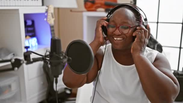 Χαμογελώντας Αφροαμερικανή Γυναίκα Αυτοπεποίθηση Τραγούδι Λικνίζοντας Μουσικό Στούντιο Καθώς Τραγουδάει — Αρχείο Βίντεο