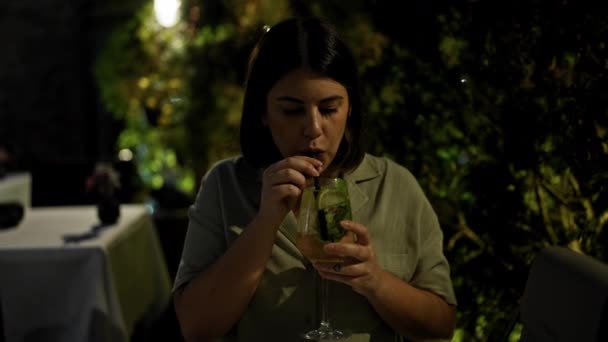 年轻美丽的惊慌失措的女人在餐馆里喝着热带鸡尾酒 — 图库视频影像