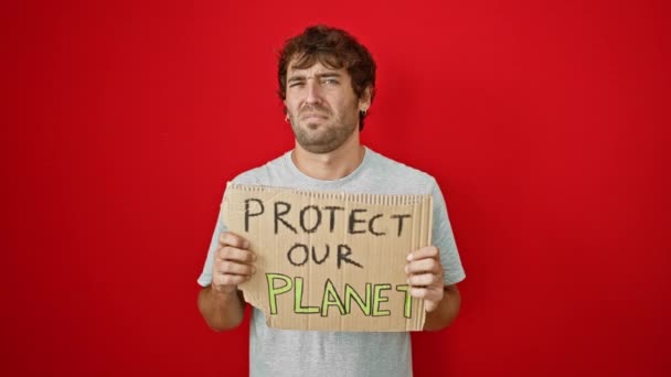 Безмозглый Молодой Человек Размахивая Плакатом Защити Нашу Планету Красном Изолированном — стоковое видео