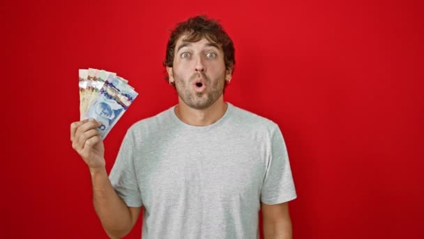 Niesamowity Młody Człowiek Trzymający Kanadyjskie Banknoty Dolarowe Zdziwionym Przerażonym Wyrazem — Wideo stockowe