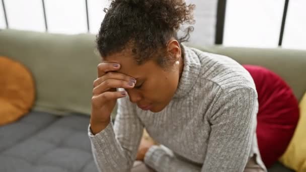 紧张的女人坐在室内把头抬起来 对着家庭环境表示担心或头痛 — 图库视频影像