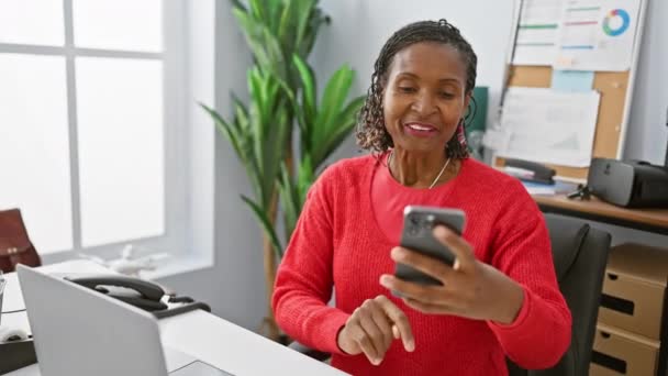 Mujer Afroamericana Sonriente Usando Smartphone Oficina Moderna Con Plantas Laptop — Vídeo de stock