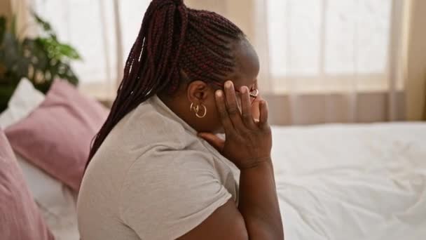一个身材魁梧 头戴辫子的非洲女人 看上去被压力压得喘不过气来 躺在床上 疲惫不堪 忧心忡忡 在舒适的卧室里挣扎着精神上的痛苦 — 图库视频影像