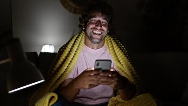 Uomo Sorridente Con Capelli Ricci Utilizzando Smartphone Notte All Interno — Video Stock
