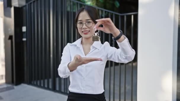 Smiling Asian Woman Business Attire Presenting House Keys Urban Setting — Stock Video
